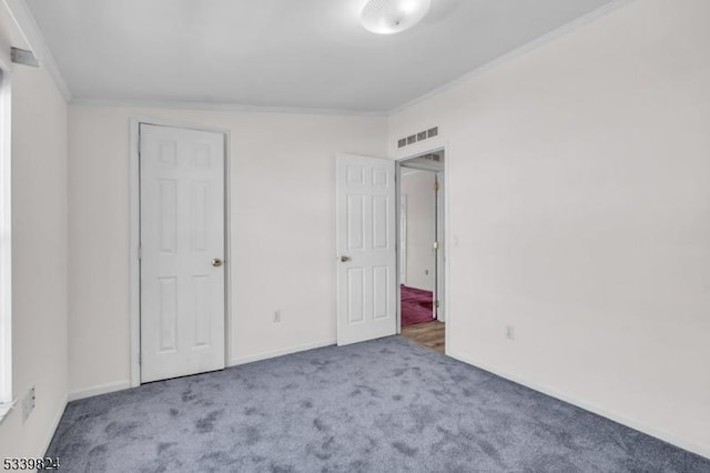 unfurnished bedroom with baseboards, carpet, visible vents, and crown molding