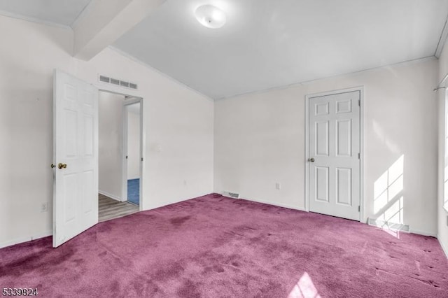 carpeted spare room with visible vents and vaulted ceiling with beams