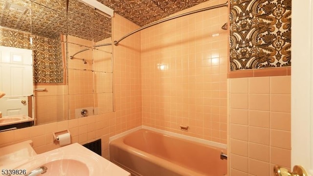 full bathroom with shower / bathtub combination and tile walls
