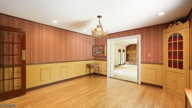 unfurnished room with wainscoting, a chandelier, recessed lighting, wallpapered walls, and wood finished floors
