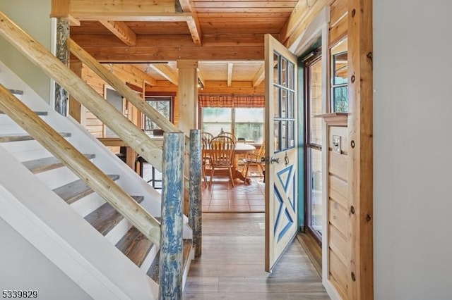 stairs with wood ceiling, beam ceiling, and wood finished floors