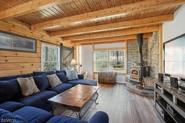 living room featuring a barn door, wooden ceiling, wood finished floors, and a wealth of natural light