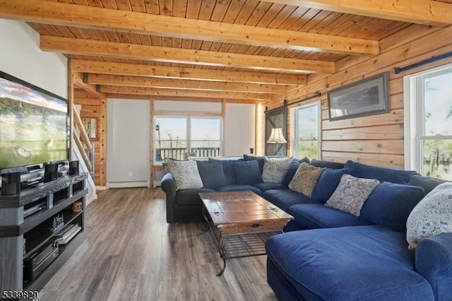 living room with wooden ceiling, wood finished floors, baseboard heating, wood walls, and beam ceiling