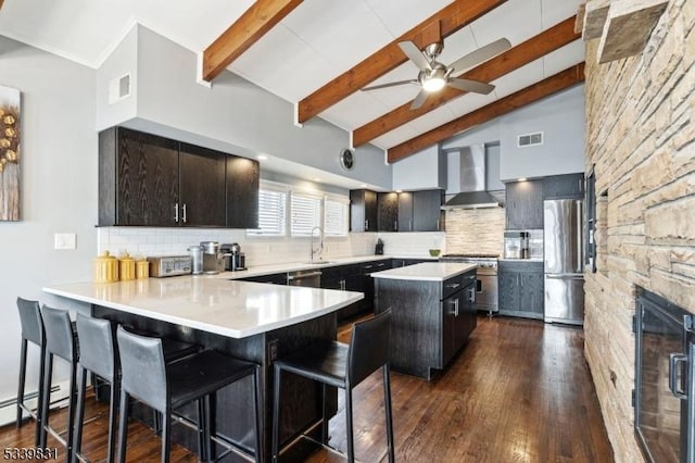 kitchen featuring wine cooler, stainless steel appliances, visible vents, decorative backsplash, and wall chimney range hood