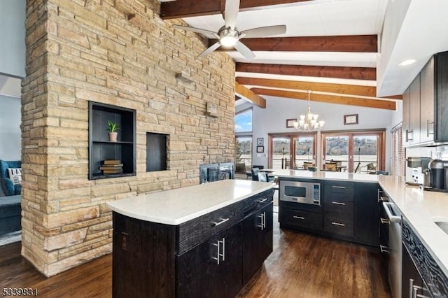 kitchen featuring lofted ceiling with beams, dark wood-style flooring, a peninsula, stainless steel appliances, and light countertops