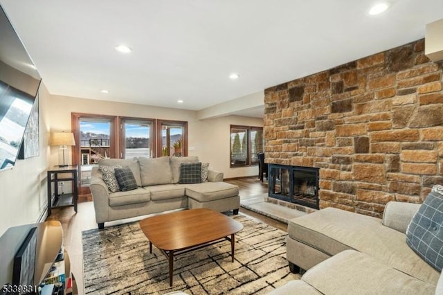 living area with recessed lighting, a fireplace, baseboards, and wood finished floors