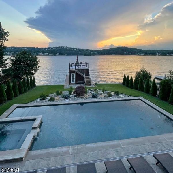 view of swimming pool with a boat dock and a water view