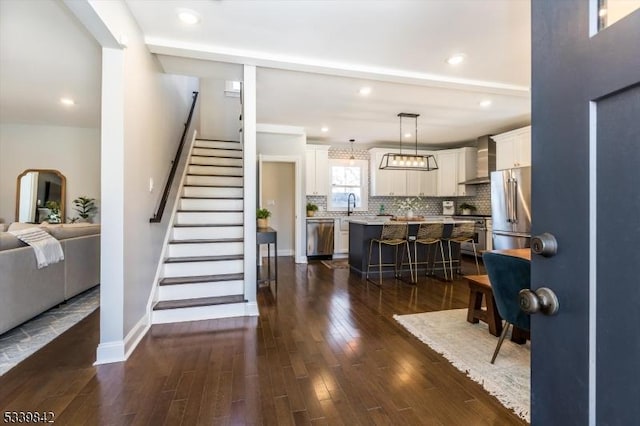 interior space featuring dark wood finished floors, stairs, recessed lighting, and baseboards