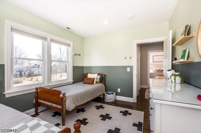 bedroom with dark wood-type flooring and baseboards