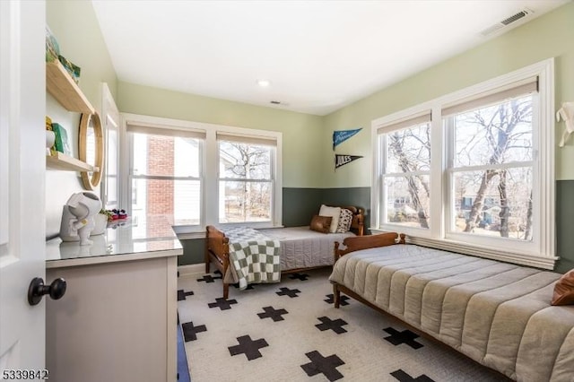 bedroom featuring visible vents and light carpet