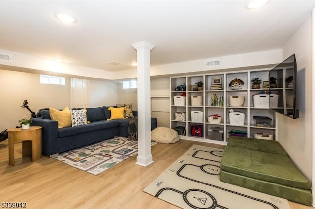 living room with visible vents, decorative columns, and wood finished floors