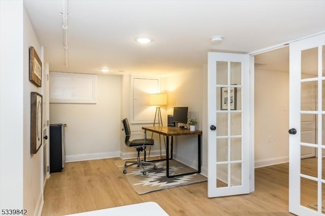 office space featuring french doors, baseboards, and light wood finished floors