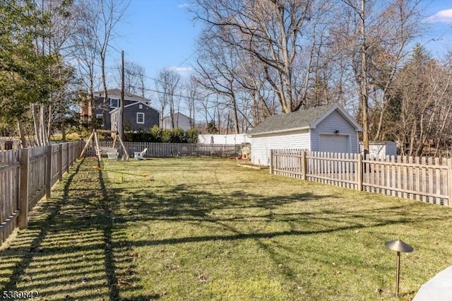 view of yard with an outbuilding, a detached garage, and a fenced backyard