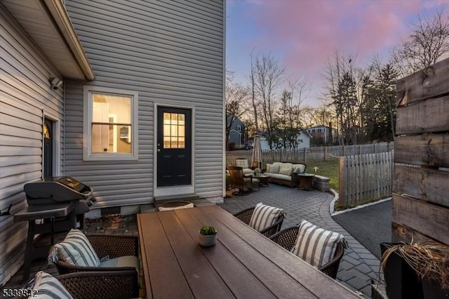 wooden terrace featuring area for grilling, outdoor dining space, a patio, fence, and an outdoor hangout area