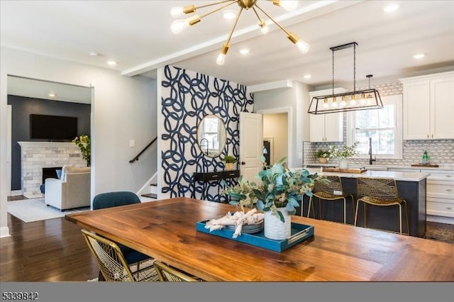 dining room with dark wood-type flooring, a notable chandelier, recessed lighting, stairway, and baseboards