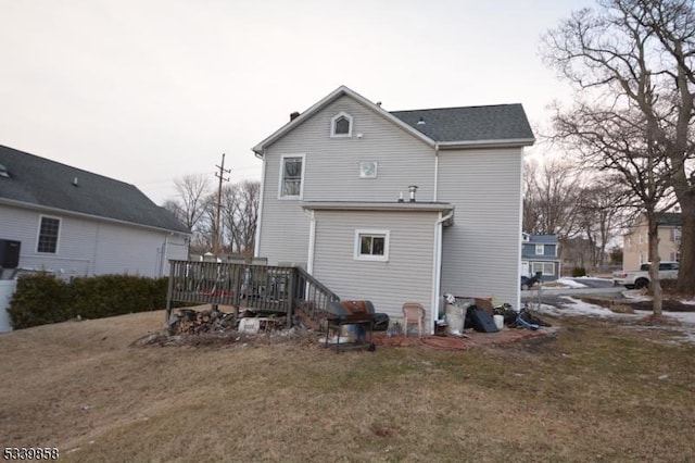 back of property featuring a yard and a wooden deck