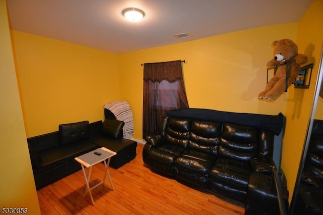 living room featuring visible vents and wood finished floors