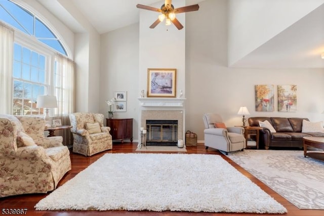 living room with a fireplace with flush hearth, high vaulted ceiling, dark wood finished floors, and a ceiling fan