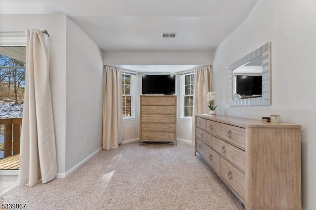 bedroom with light carpet, multiple windows, visible vents, and baseboards