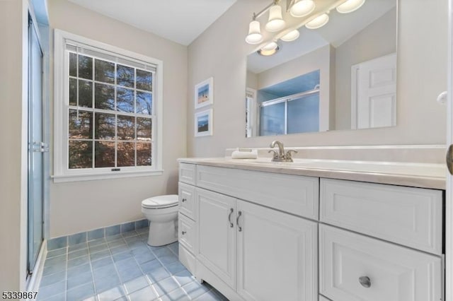 full bathroom featuring a stall shower, tile patterned flooring, vanity, and baseboards