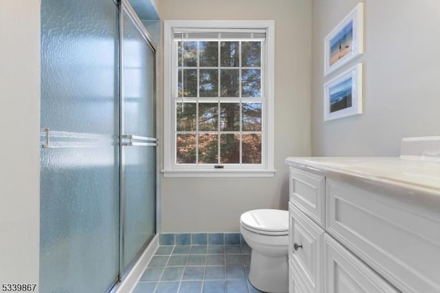 full bath featuring toilet, vanity, a shower stall, tile patterned flooring, and baseboards