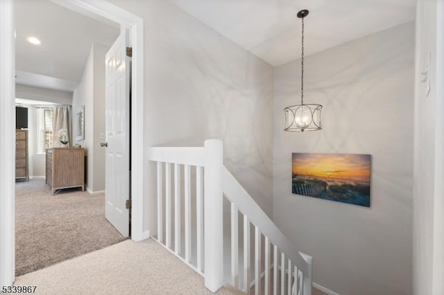 hallway featuring recessed lighting, an inviting chandelier, light carpet, an upstairs landing, and baseboards