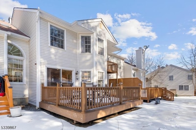 snow covered house with a deck