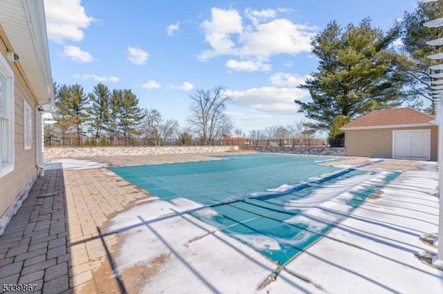 view of swimming pool with a patio, an outdoor structure, a fenced backyard, and a fenced in pool