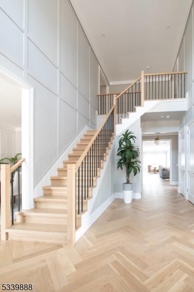 stairway with a high ceiling and a decorative wall