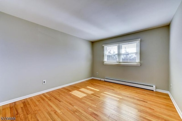 unfurnished room with light wood finished floors, baseboards, and baseboard heating