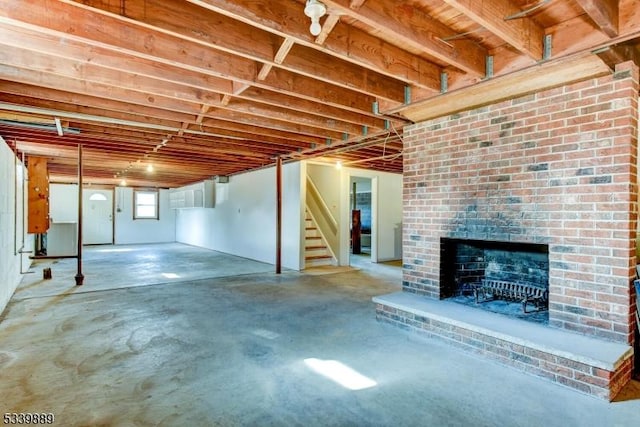 below grade area featuring stairway and a brick fireplace