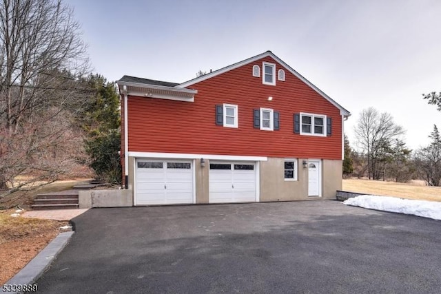 view of side of property with a garage and driveway