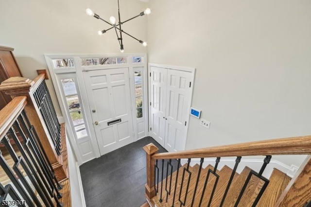 foyer entrance with a chandelier, stairs, and a towering ceiling