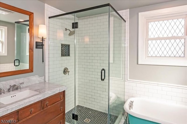 full bath with visible vents, a freestanding tub, a shower stall, and vanity