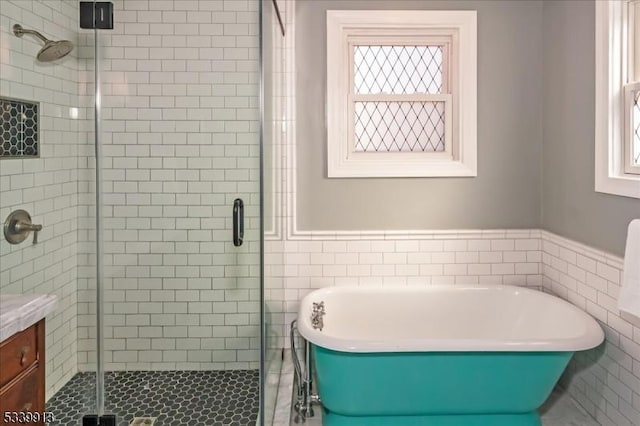 full bath with a soaking tub, a shower stall, tile walls, and a healthy amount of sunlight