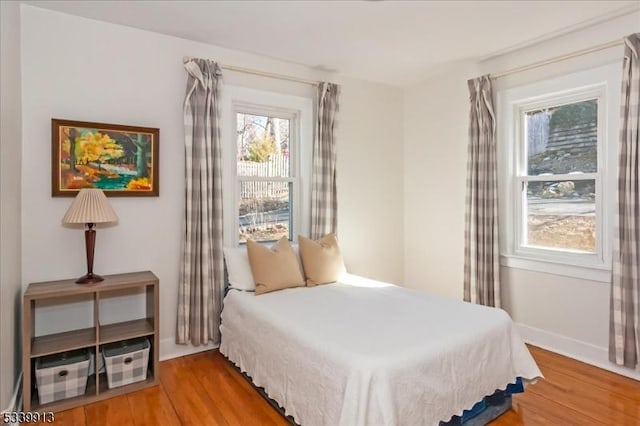 bedroom with baseboards and wood finished floors