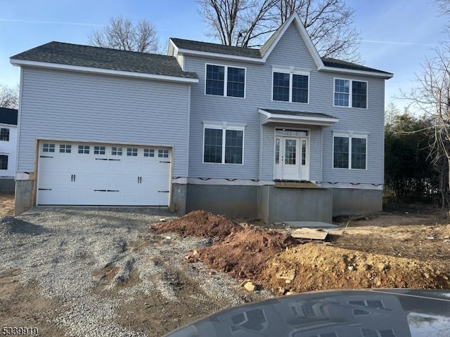 colonial-style house featuring driveway and a garage