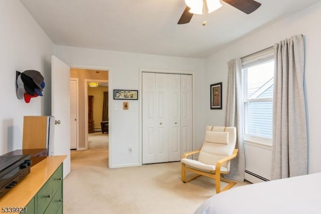 bedroom with light carpet, baseboards, a baseboard radiator, ceiling fan, and a closet