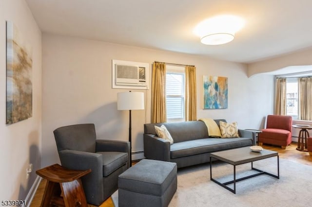 living room featuring a healthy amount of sunlight, light wood-type flooring, a baseboard radiator, and baseboards