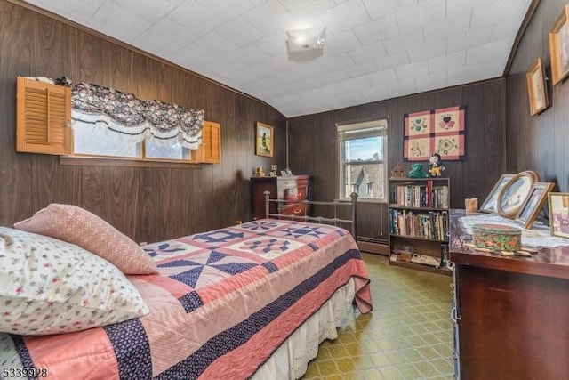 bedroom with a baseboard heating unit, wooden walls, and tile patterned floors