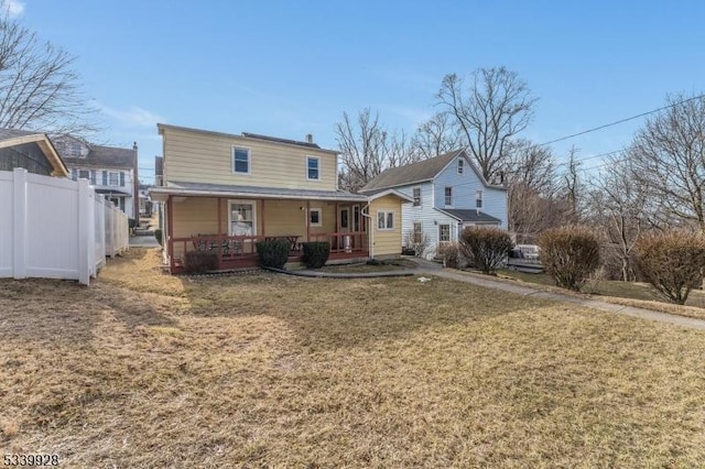 view of front of house featuring a porch, a front yard, and fence