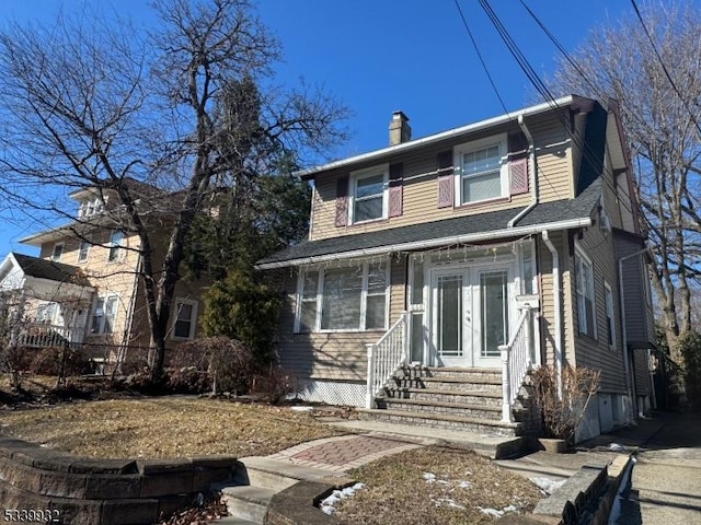 view of front of home featuring entry steps and a chimney