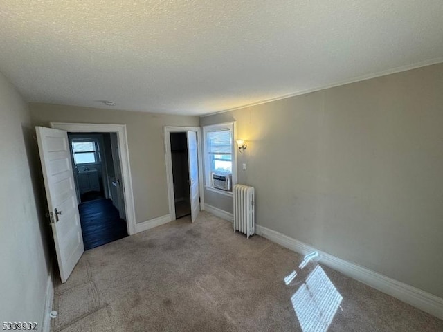 bedroom featuring radiator, multiple windows, baseboards, and light carpet