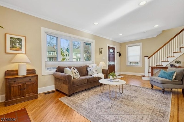 living room with baseboards, plenty of natural light, stairway, and light wood finished floors