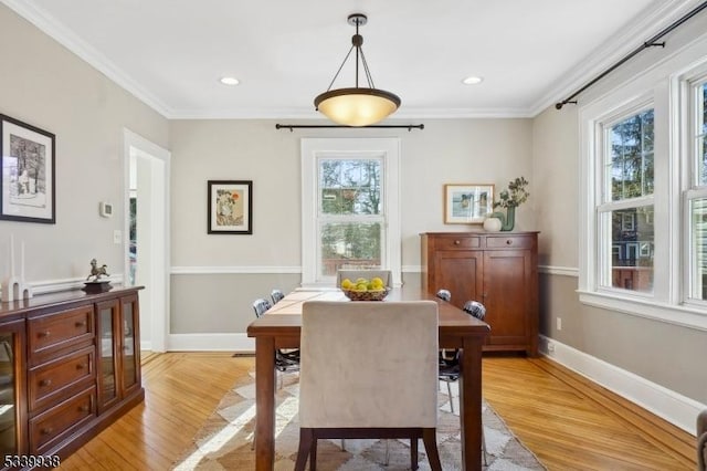 dining area with crown molding, baseboards, plenty of natural light, and light wood finished floors