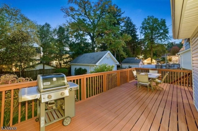 deck featuring outdoor dining area, grilling area, and fence