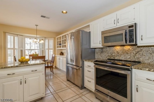 kitchen featuring visible vents, hanging light fixtures, appliances with stainless steel finishes, white cabinetry, and light stone countertops