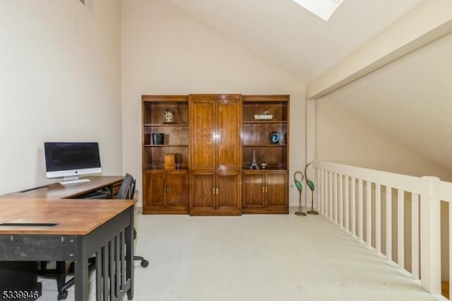 office area with lofted ceiling with skylight and light colored carpet