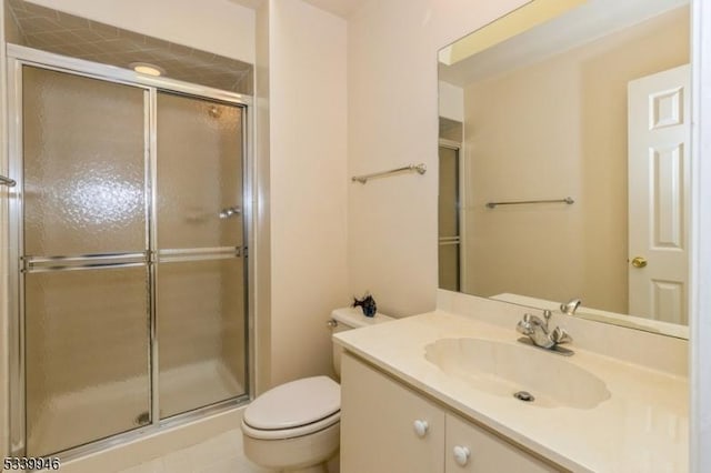 bathroom featuring toilet, a shower stall, and vanity