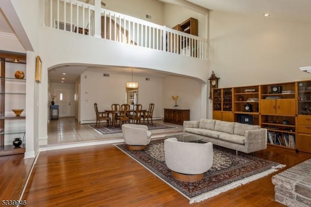 living room featuring arched walkways and wood finished floors